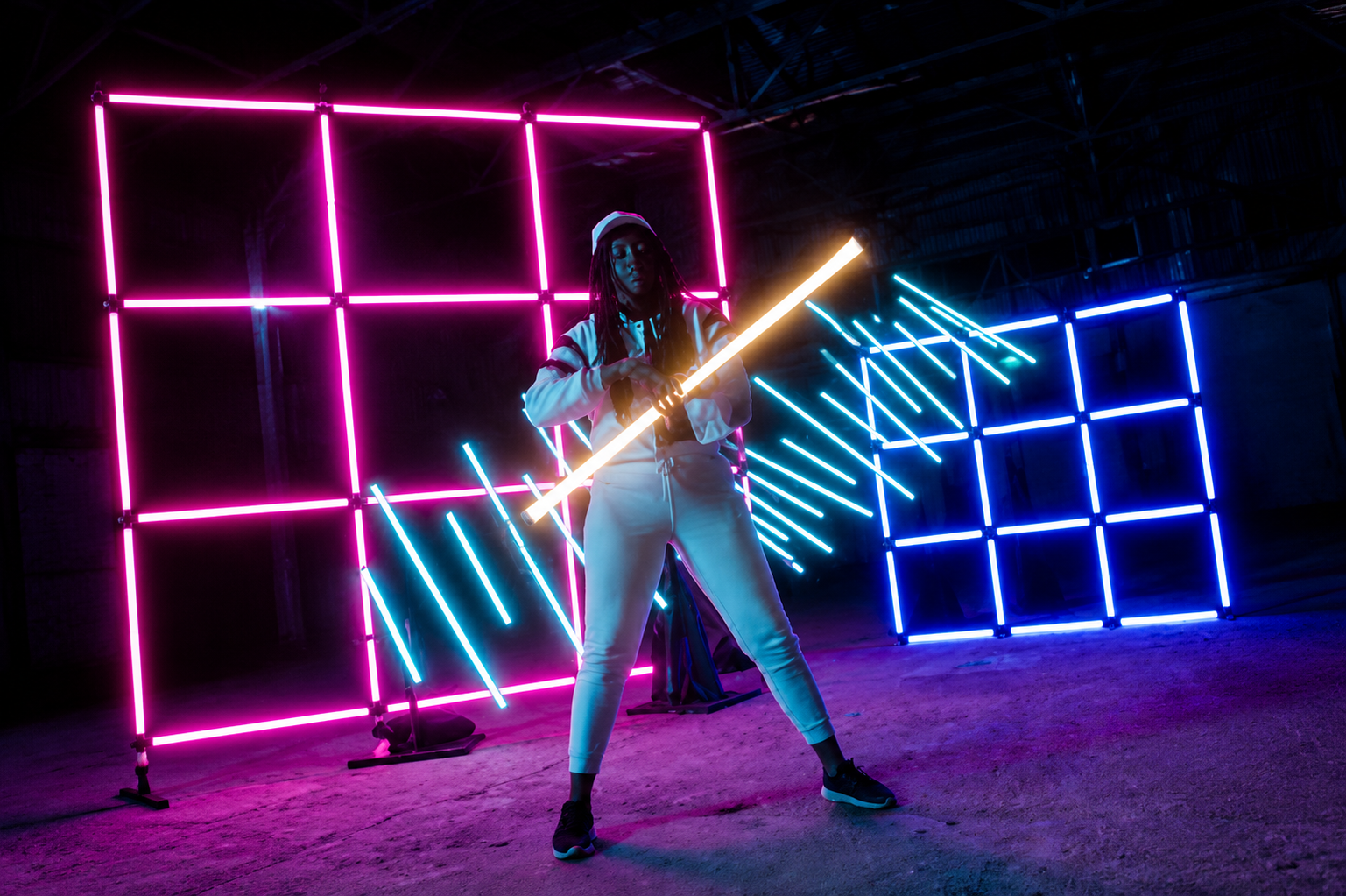 Performer surrounded by colourful Amaran tube-light shapes on an event stage