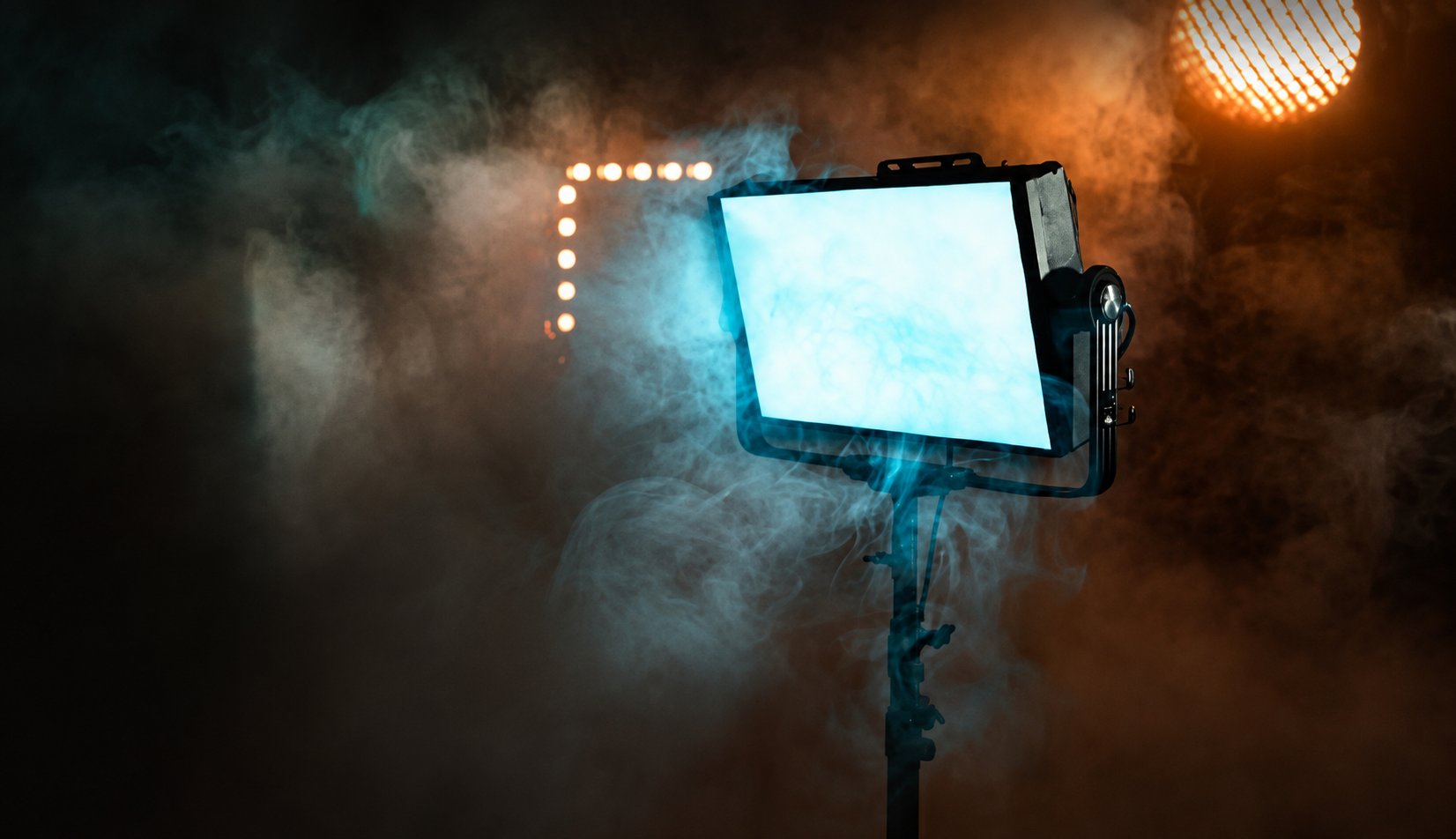 Aputure Nova-style LED panel creating cyan and amber event lighting through theatrical haze