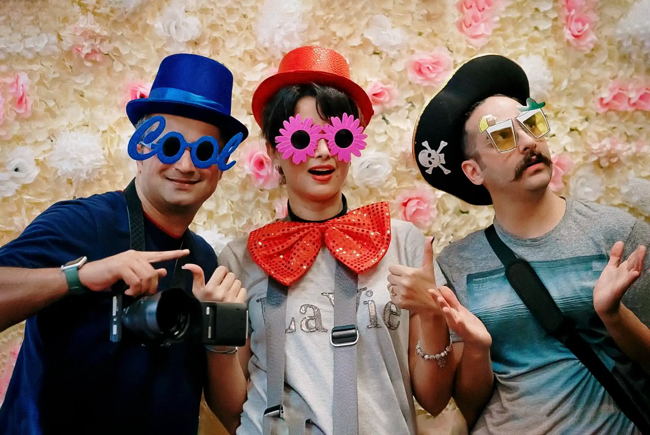 HAPfilm team members in colorful costumes and props at a photo booth during a New Zealand wedding