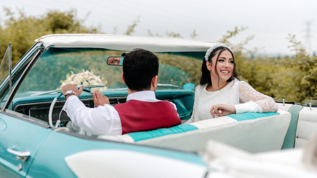Couple sharing a loving moment in the front seat of a classic car, captured by HAPfilm’s wedding photography in Auckland