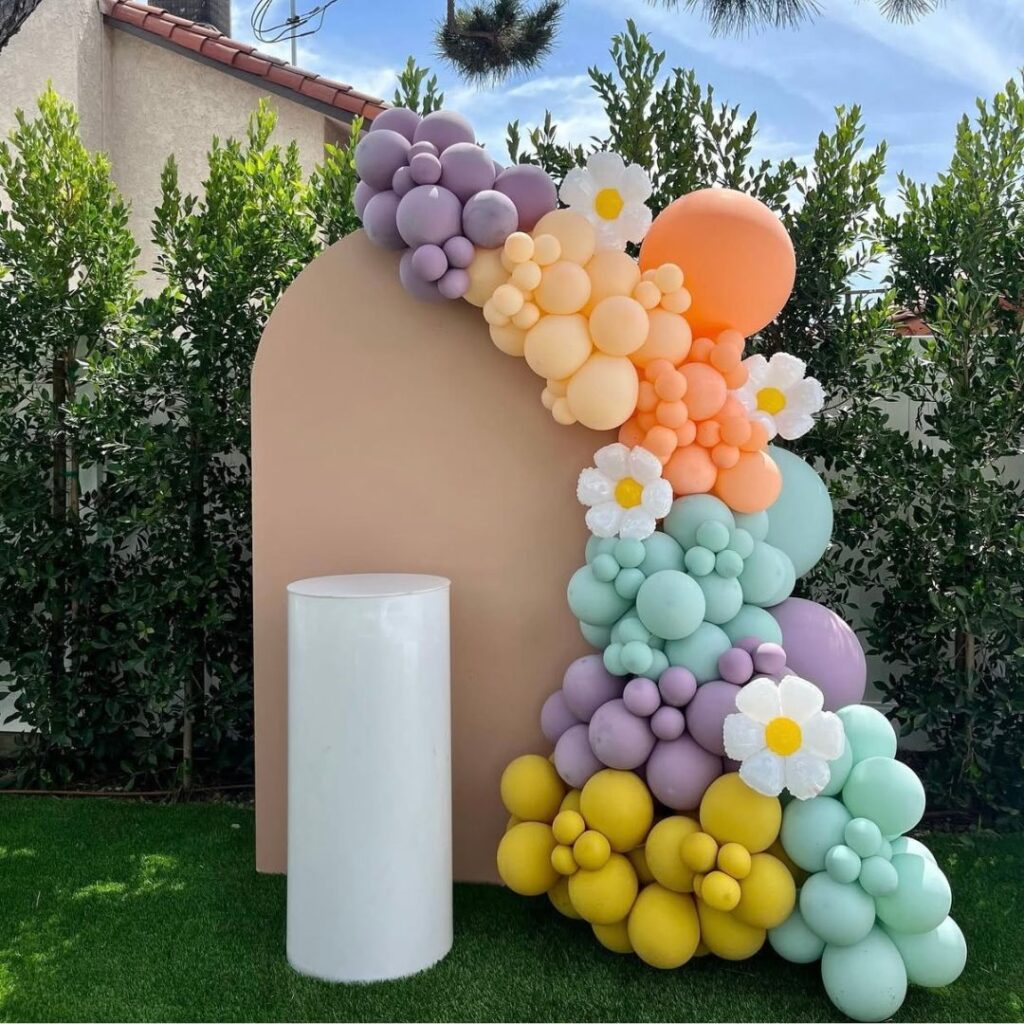 Organic balloon decor installation in pink, red, and gold, featuring a neon "Twenty One" sign. The arch is styled for a 21st birthday party in Auckland.
